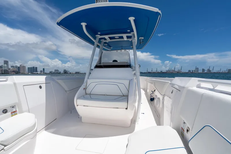 Slide: The Image of 2021 Intrepid 345 Nomad FE boat interior with blue canopy, city skyline in background. - 41