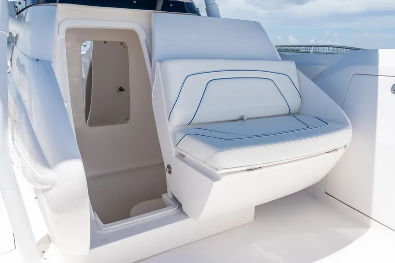 Slide: The Image of 2021 Intrepid 345 Nomad FE boat interior with white seating and storage compartment. - 44