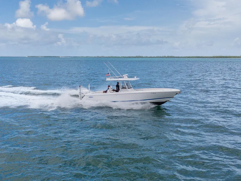 Slide: The Image of 2021 Intrepid 345 Nomad FE cruising on open water under a clear sky. - 8