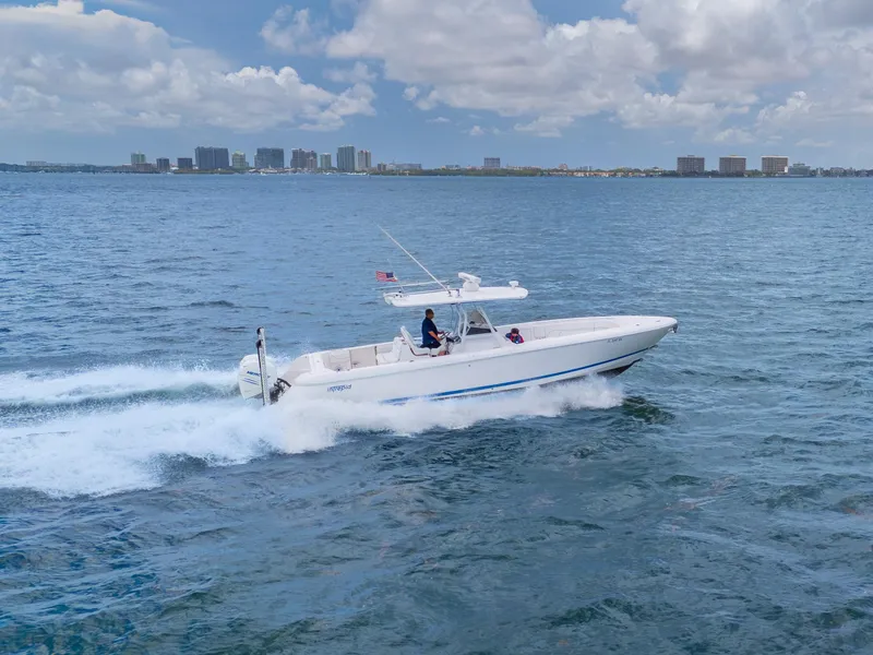 Slide: The Image of 2021 Intrepid 345 Nomad FE cruising on open water with city skyline in background. - 9
