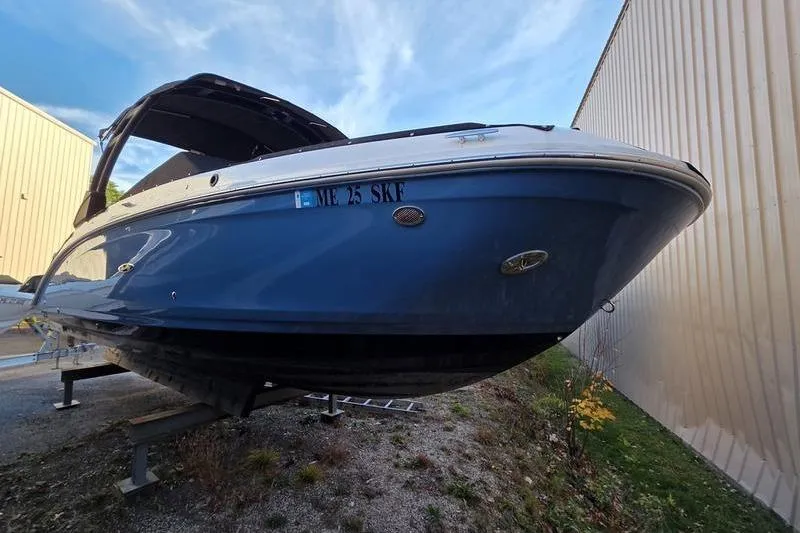 Slide: The Image of 2024 Sea Ray 270 Sundeck boat on display, blue hull, parked outdoors. - 4