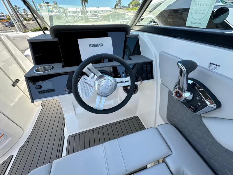 Slide: The Image of 2024 Sea Ray SDX 270 Outboard helm with steering wheel and control panel. - 15