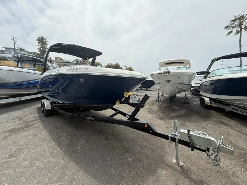 Slide: The Image of 2024 Sea Ray SDX 270 Outboard boat on trailer, parked in marina lot. - 2