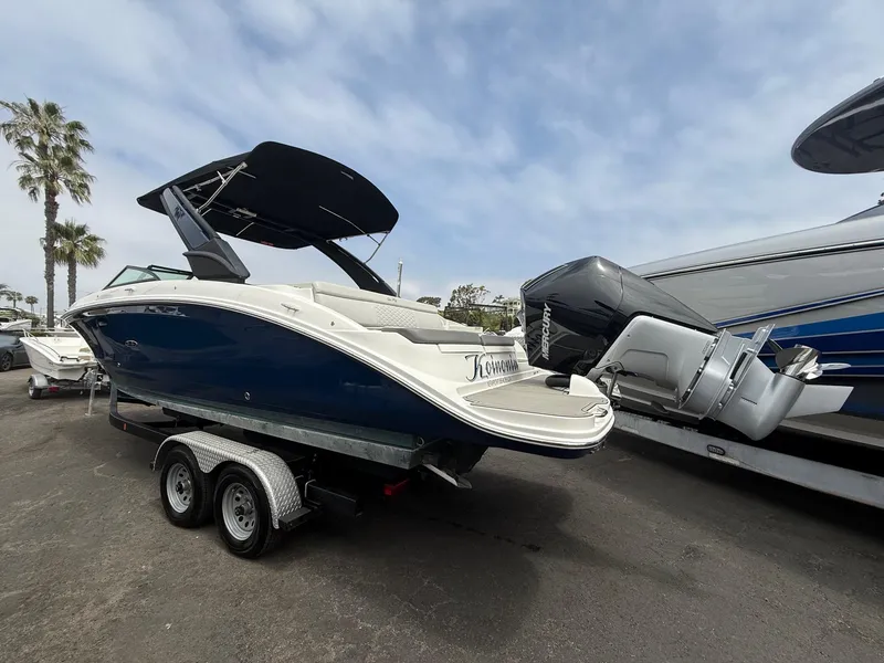 Slide: The Image of 2024 Sea Ray SDX 270 Outboard boat on trailer, parked outdoors under cloudy sky. - 4
