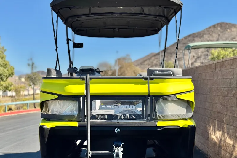 Slide: The Image of 2023 Sea-Doo Switch Cruise 21, vibrant yellow, parked outdoors with canopy. - 2