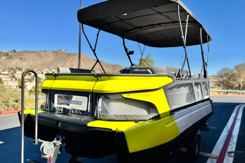 Slide: The Image of 2023 Sea-Doo Switch Cruise 21 pontoon boat with canopy, parked on a sunny day. - 3