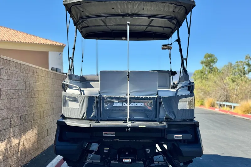 Slide: The Image of 2023 Sea-Doo Switch Cruise 21 pontoon boat, rear view, parked outdoors. - 6
