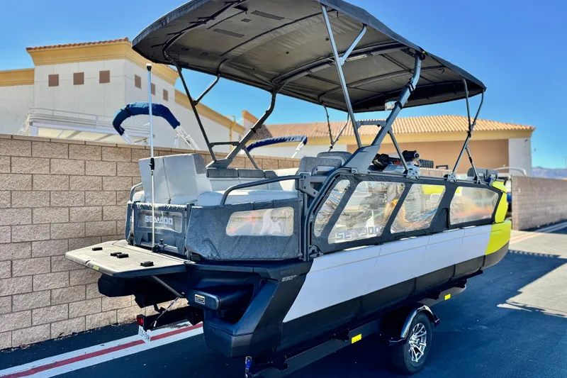 Slide: The Image of 2023 Sea-Doo Switch Cruise 21 pontoon boat with canopy, parked on a trailer. - 7