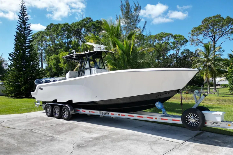 The Image of 2024 SeaVee 340Z boat on trailer, surrounded by lush greenery and palm trees. - 1
