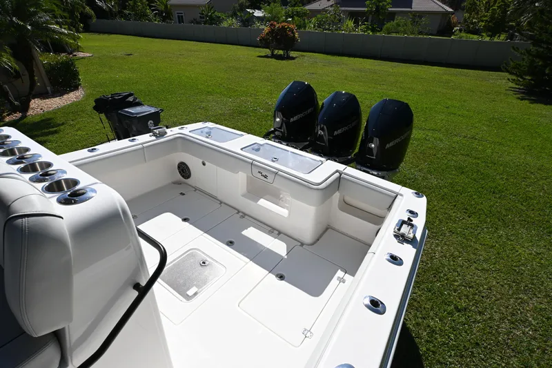 Slide: The Image of 2024 SeaVee 340Z boat with triple Mercury engines, spacious deck, and rod holders. - 9