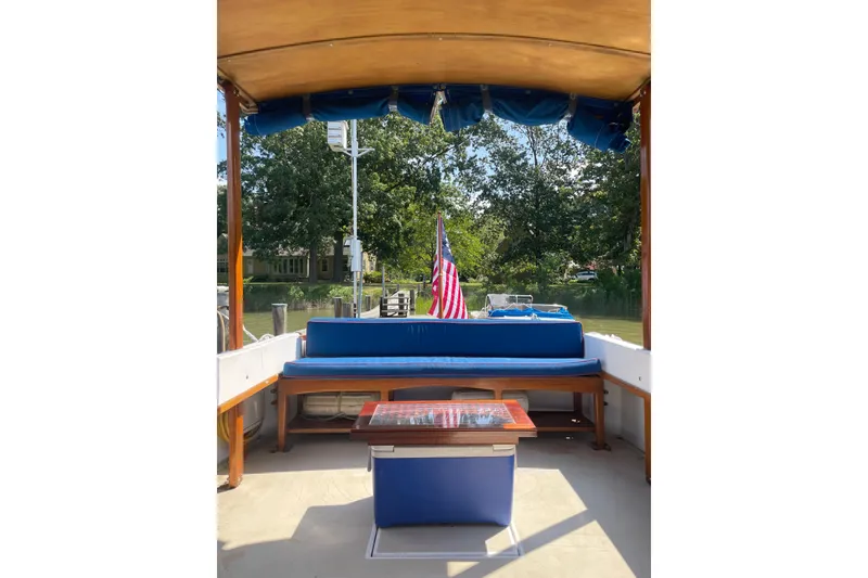 Slide: The Image of 1988 Cape Dory Hardtop boat interior with blue seating and American flag. - 16
