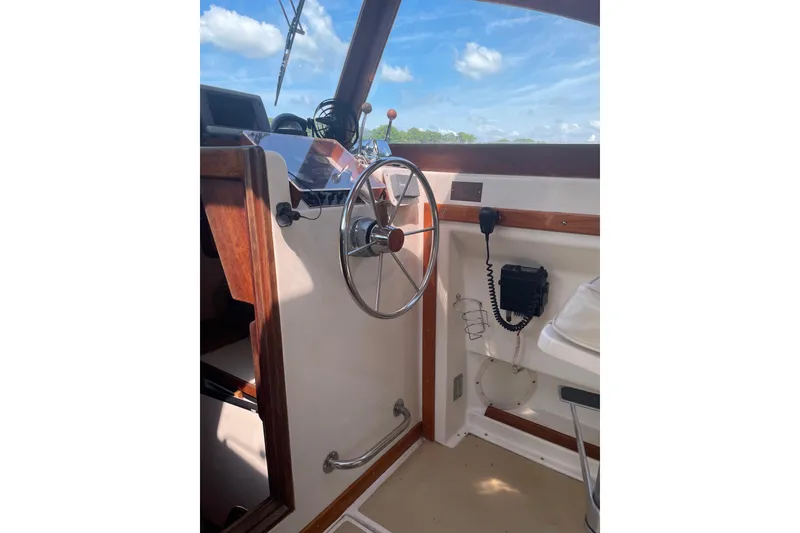 Slide: The Image of 1988 Cape Dory Hardtop boat interior with steering wheel and communication equipment. - 18