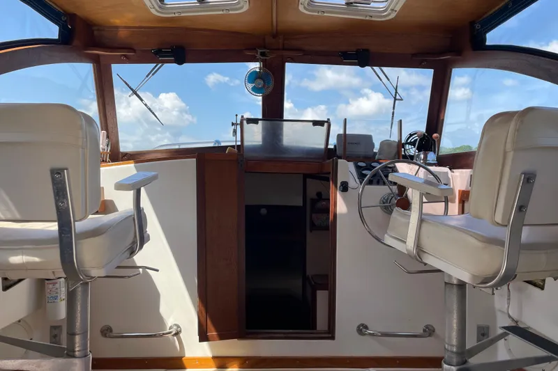 Slide: The Image of Interior of a 1988 Cape Dory Hardtop boat with steering wheel and seating. - 20