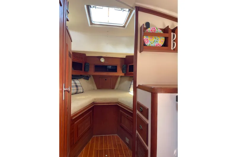 Slide: The Image of 1988 Cape Dory Hardtop cabin interior with wood finish and cozy sleeping area. - 23