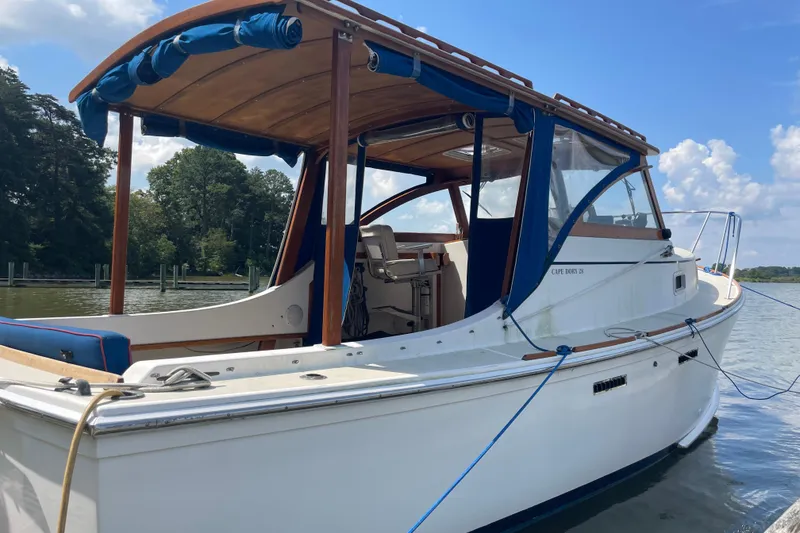 Slide: The Image of 1988 Cape Dory Hardtop boat docked on a sunny day, featuring wooden accents. - 5