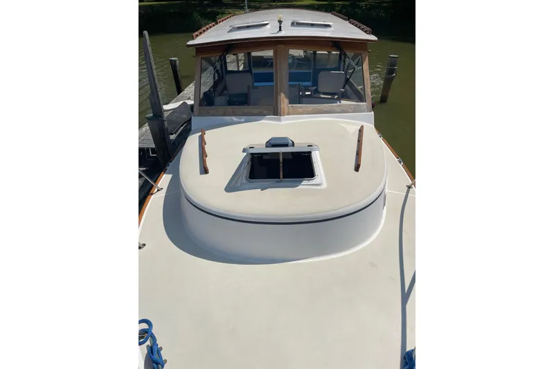Slide: The Image of 1988 Cape Dory Hardtop boat with open hatch, docked on calm water. - 6