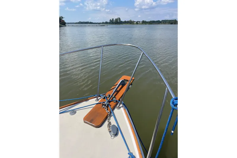 Slide: The Image of 1988 Cape Dory Hardtop boat bow with railing, anchored on calm water. - 7