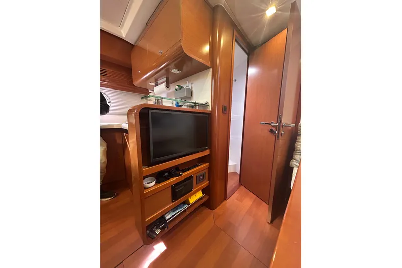 Slide: The Image of Interior of 2012 Beneteau Gran Turismo 44 yacht with TV and wooden cabinetry. - 33