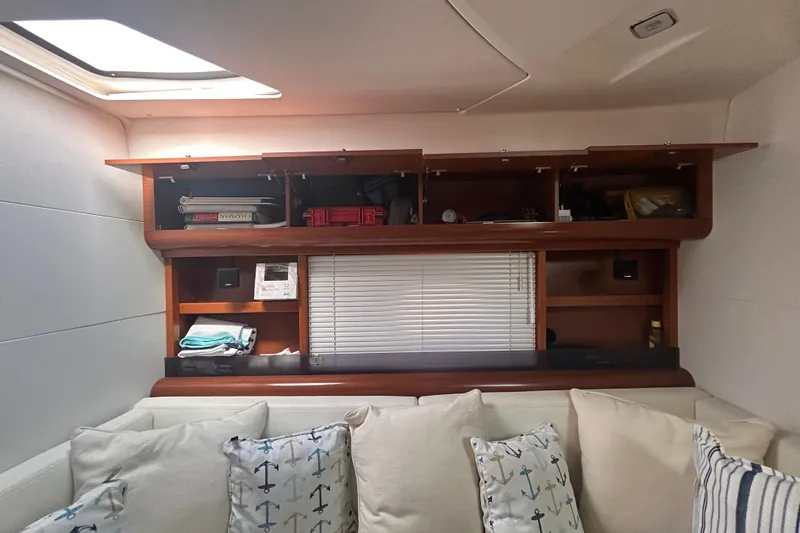 Slide: The Image of Interior of 2012 Beneteau Gran Turismo 44 with wooden shelves and nautical-themed cushions. - 38