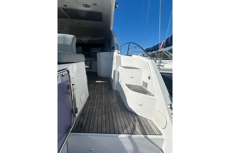 Slide: The Image of 2012 Beneteau Gran Turismo 44 yacht deck with seating and steps, under clear blue sky. - 9
