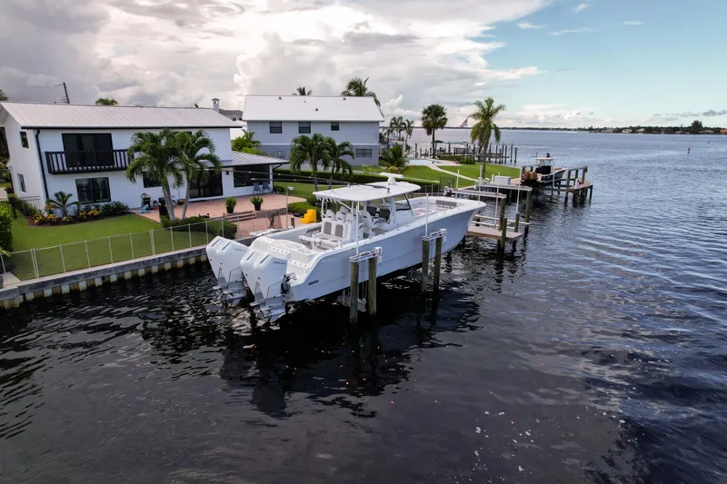 Slide: The Image of 2025 Front Runner 43 Catamaran docked by waterfront homes, under a partly cloudy sky. - 18