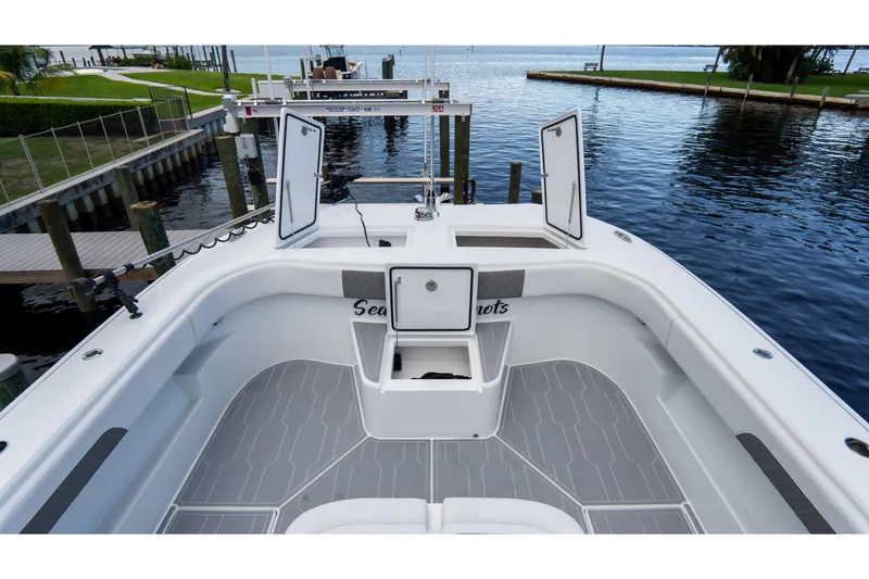 Slide: The Image of 2025 Front Runner 43 Catamaran deck with open storage compartments, docked by the water. - 22