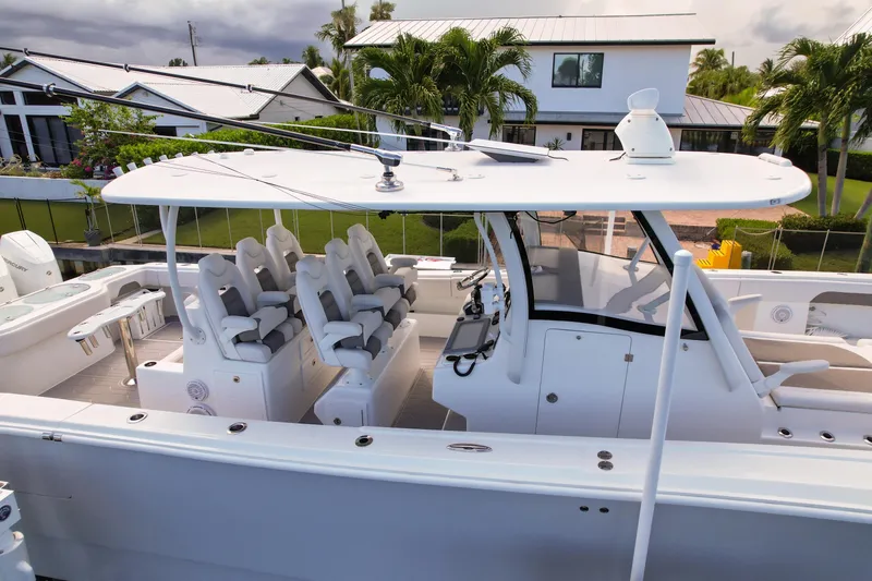 Slide: The Image of 2025 Front Runner 43 Catamaran with spacious seating and modern design, docked near a house. - 8