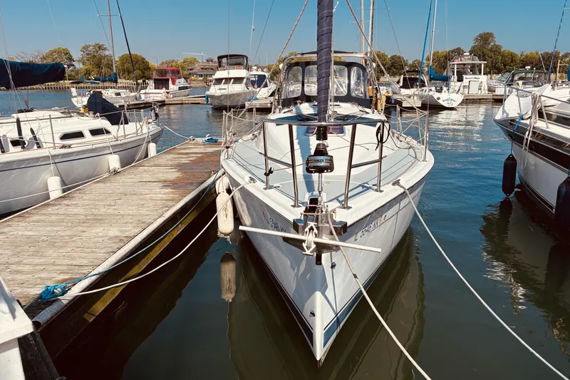 Slide: The Image of Hunter 33 sailboat from 2005 docked at a marina, surrounded by other boats. - 2