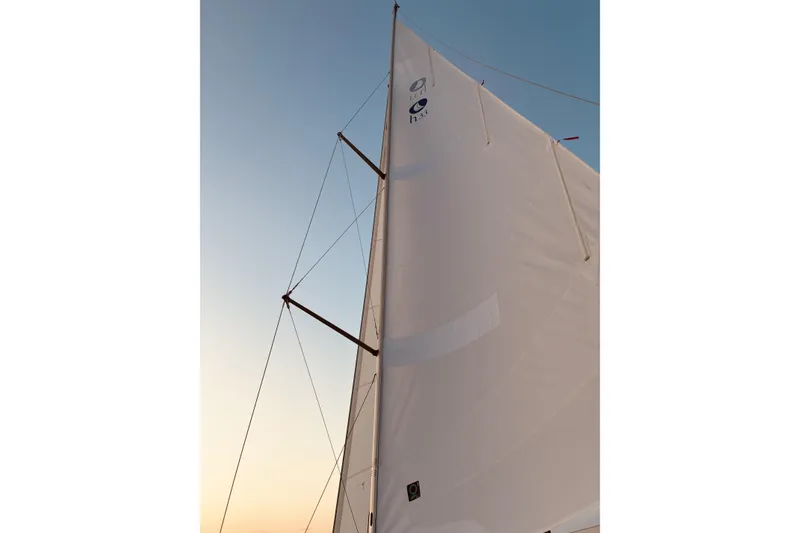 Slide: The Image of Sail of a 2005 Hunter 33 yacht against a sunset sky. - 25
