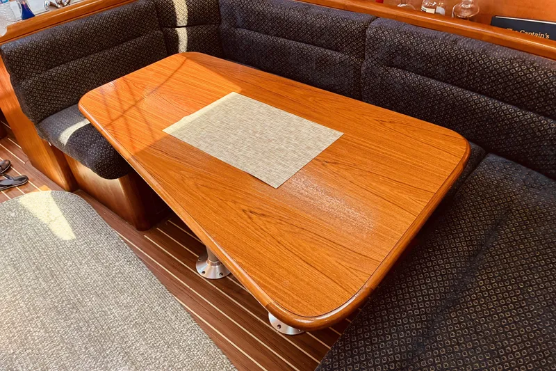 Slide: The Image of Interior of a 2005 Hunter 33 sailboat with a wooden dining table and cushioned seating. - 29