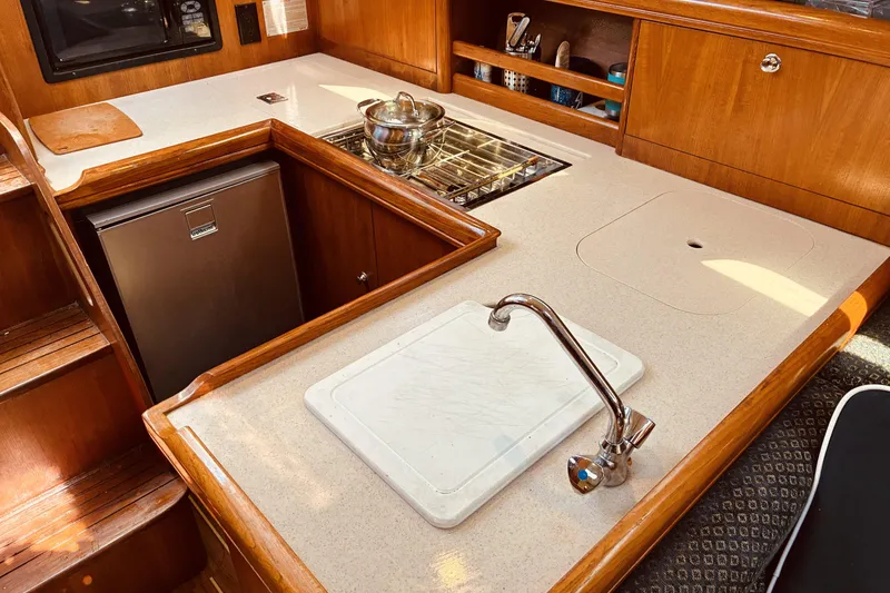 Slide: The Image of 2005 Hunter 33 yacht kitchen with wooden cabinetry and modern appliances. - 30