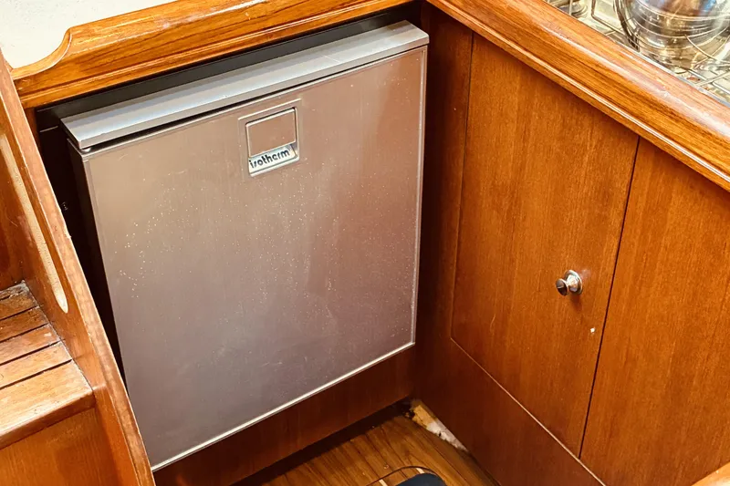 Slide: The Image of Compact fridge in 2005 Hunter 33 yacht's wooden interior kitchen area. - 31