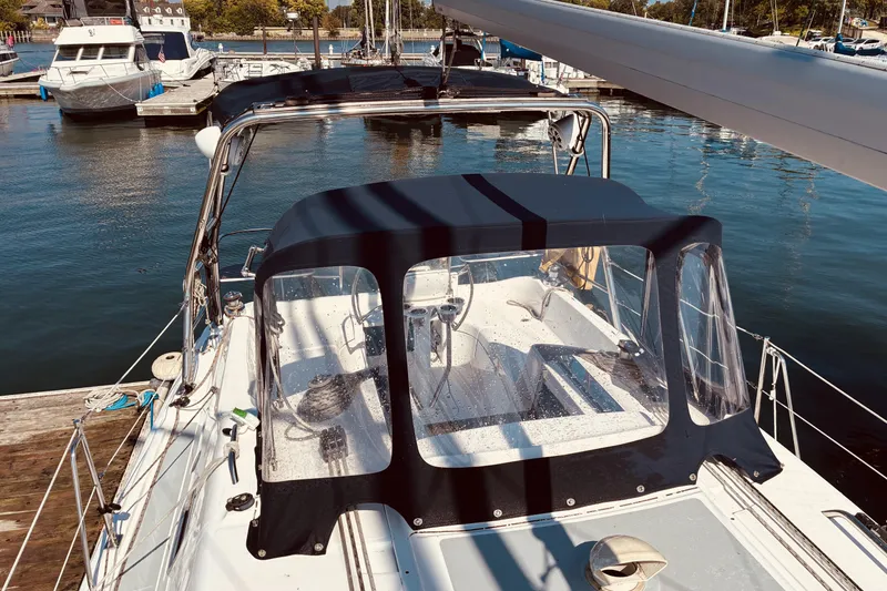 Slide: The Image of 2005 Hunter 33 sailboat docked at marina, featuring a covered cockpit area. - 4