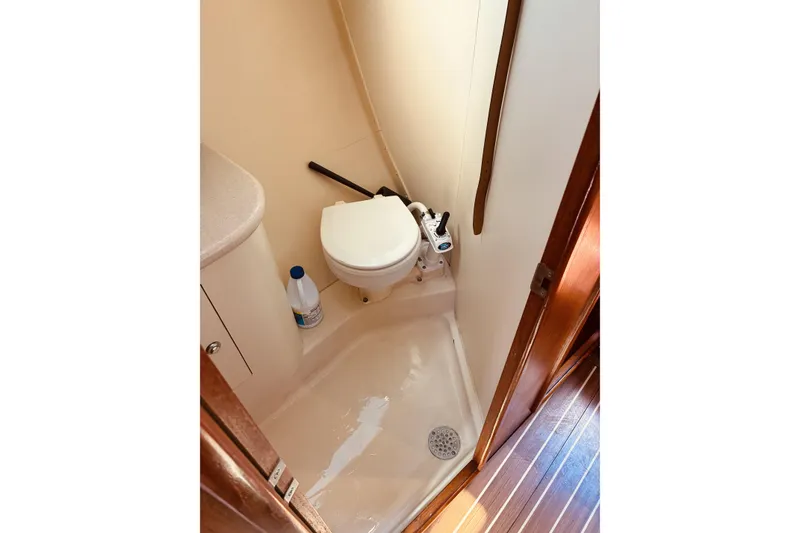 Slide: The Image of Compact bathroom in a 2005 Hunter 33 sailboat, featuring a toilet and shower area. - 42