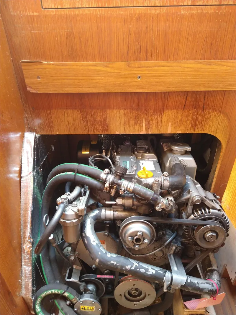 Slide: The Image of Engine compartment of a 2005 Hunter 33 sailboat, showcasing mechanical components and hoses. - 43