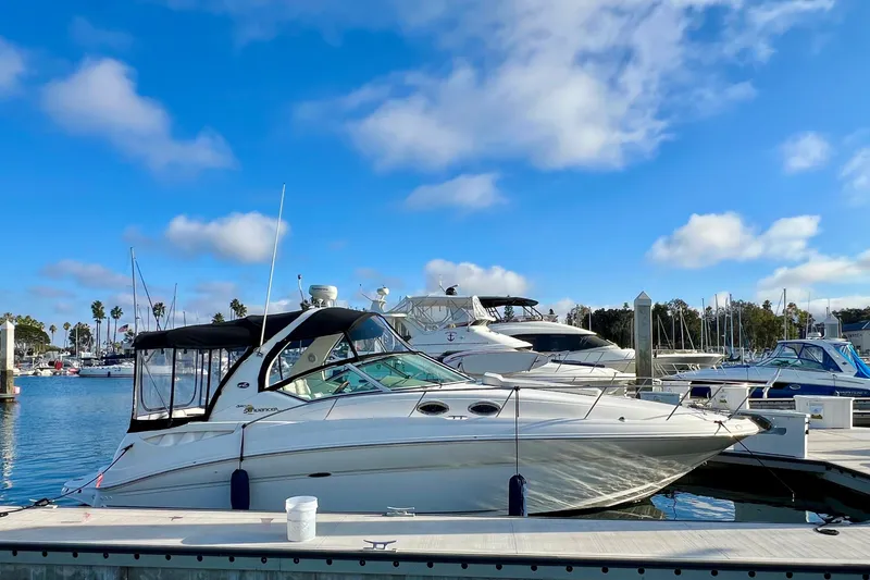 The Image of 2004 Sea Ray 320 Sundancer yacht docked in a sunny marina. - 0