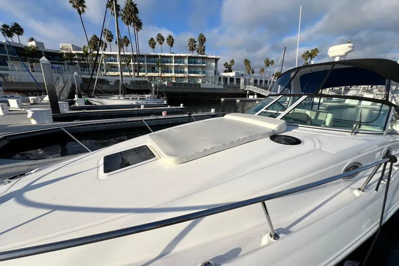 Slide: The Image of 2004 Sea Ray 320 Sundancer docked at a marina with palm trees in the background. - 17