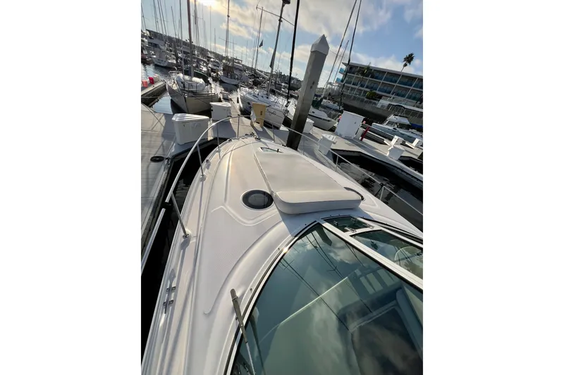 Slide: The Image of 2004 Sea Ray 320 Sundancer docked at a marina under a clear sky. - 18