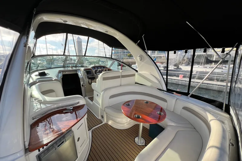 Slide: The Image of 2004 Sea Ray 320 Sundancer interior with seating and helm, docked at marina. - 22