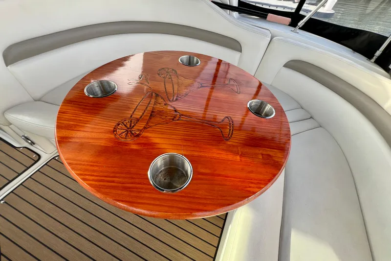 Slide: The Image of Luxurious 2004 Sea Ray 320 Sundancer boat interior with elegant wooden table and cup holders. - 26