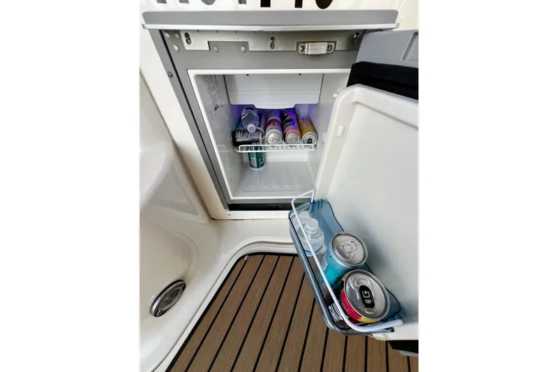 Slide: The Image of Open mini fridge on 2004 Sea Ray 320 Sundancer boat, stocked with drinks. - 29