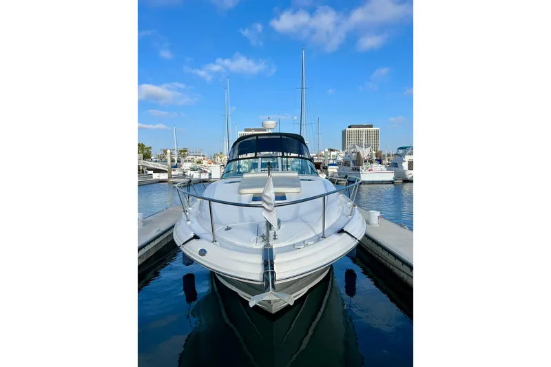 Slide: The Image of 2004 Sea Ray 320 Sundancer yacht docked in a marina under a clear blue sky. - 3