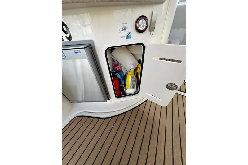 Slide: The Image of Open storage compartment on 2004 Sea Ray 320 Sundancer boat with cleaning supplies. - 31