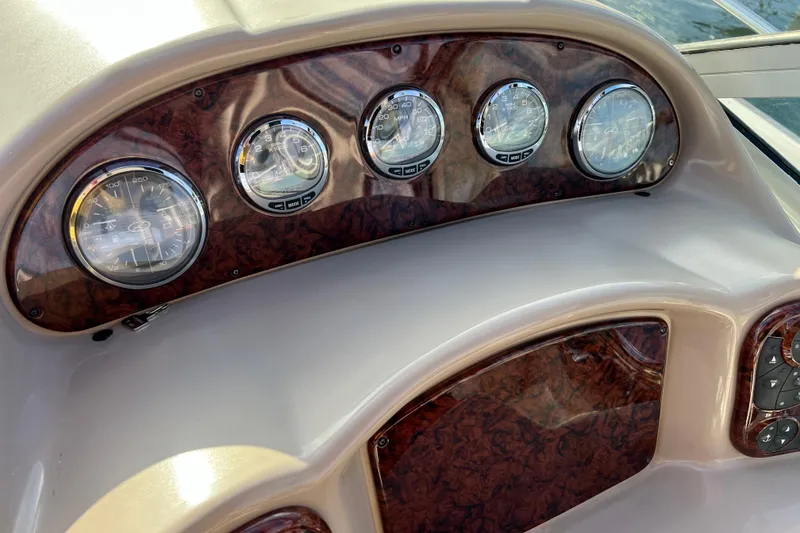 Slide: The Image of Dashboard of a 2004 Sea Ray 320 Sundancer boat with wood paneling and gauges. - 36