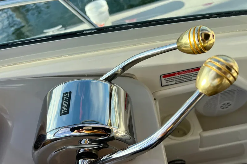 Slide: The Image of Throttle controls on a 2004 Sea Ray 320 Sundancer boat, featuring gold handles. - 39