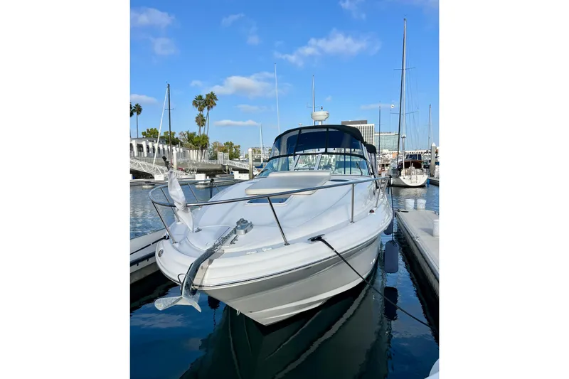 Slide: The Image of 2004 Sea Ray 320 Sundancer yacht docked in a marina under a clear blue sky. - 4