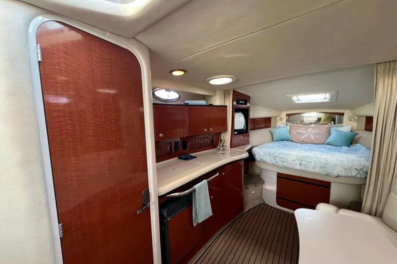 Slide: The Image of Interior of 2004 Sea Ray 320 Sundancer with cozy bed and wooden cabinetry. - 46