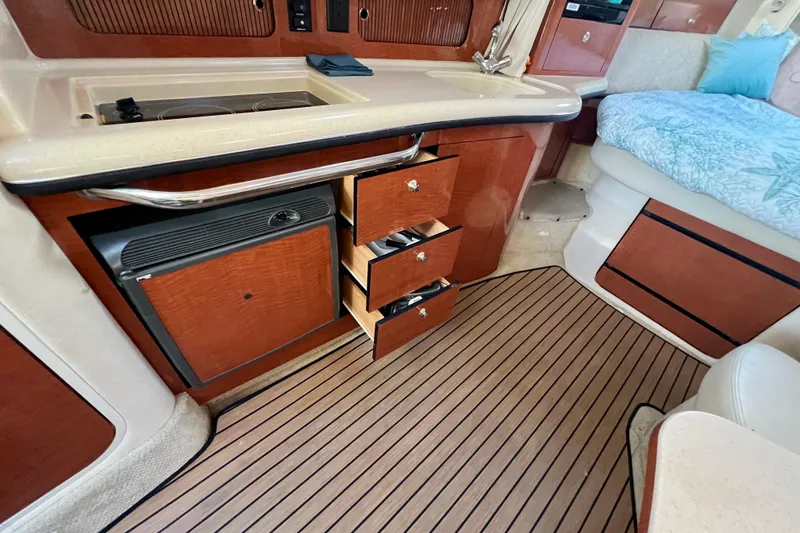 Slide: The Image of Interior of 2004 Sea Ray 320 Sundancer with kitchenette and open drawers. - 51