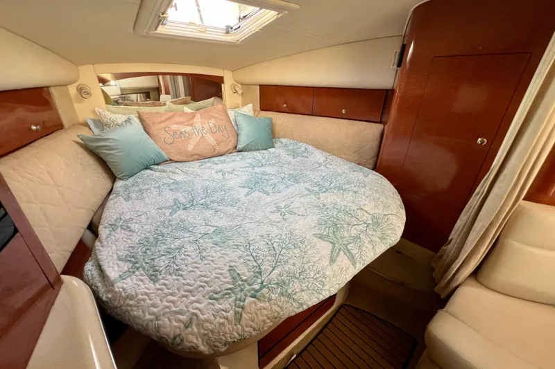 Slide: The Image of Cozy cabin interior of 2004 Sea Ray 320 Sundancer with nautical-themed bedding. - 54