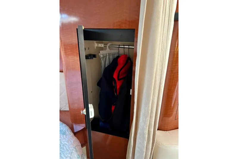 Slide: The Image of Open closet with clothes inside on a 2004 Sea Ray 320 Sundancer yacht. - 55
